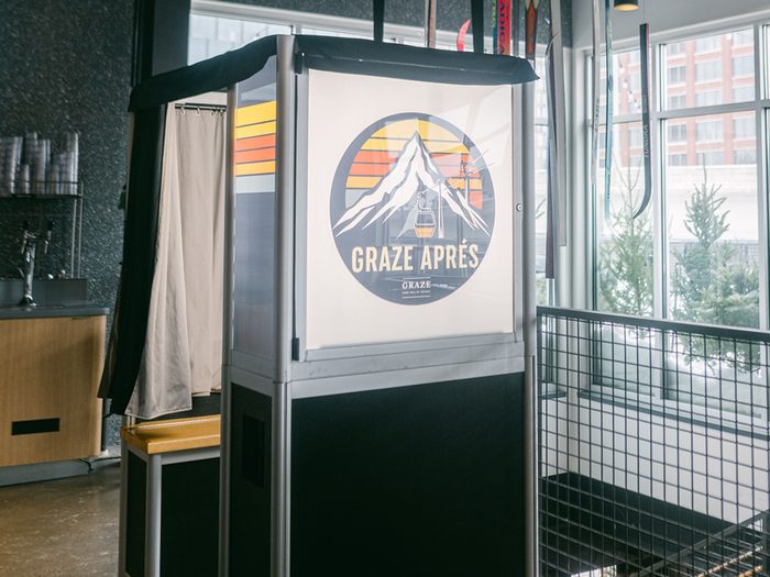 Enclosed booth in a taproom with the venue logo on the light box