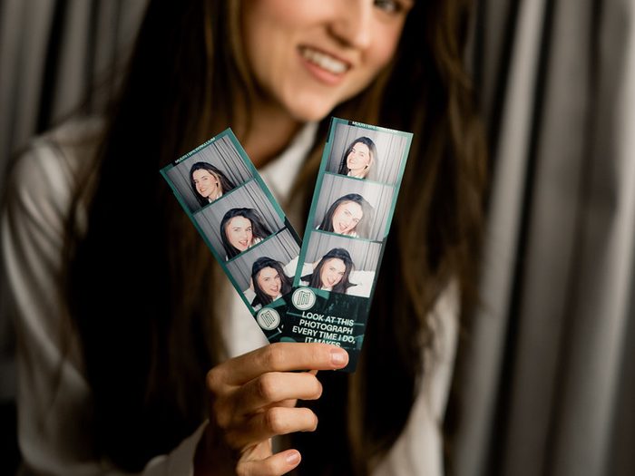 A guest holding two branded photo strips